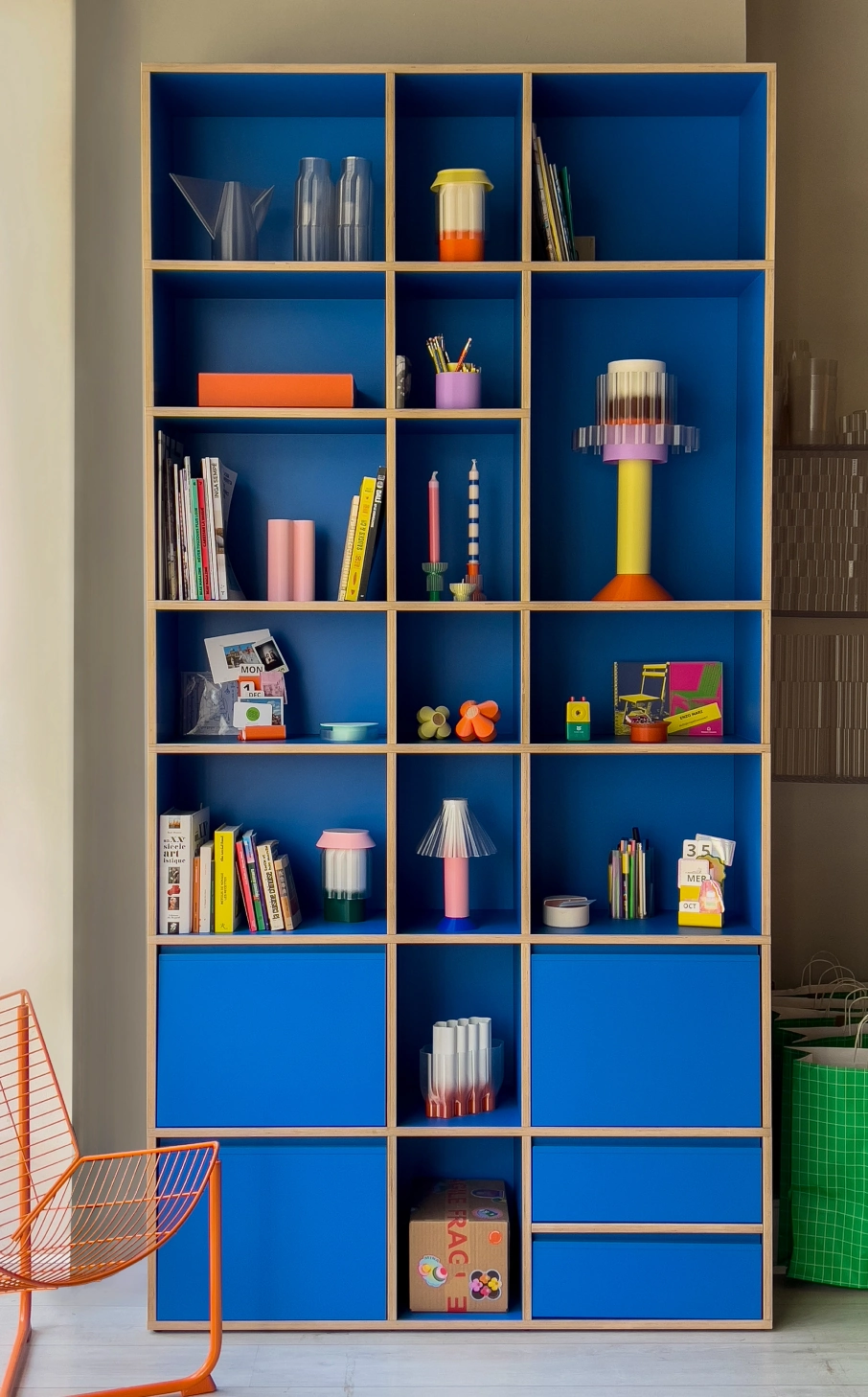 A white open-carcass bookcase standing full height against a plain wall